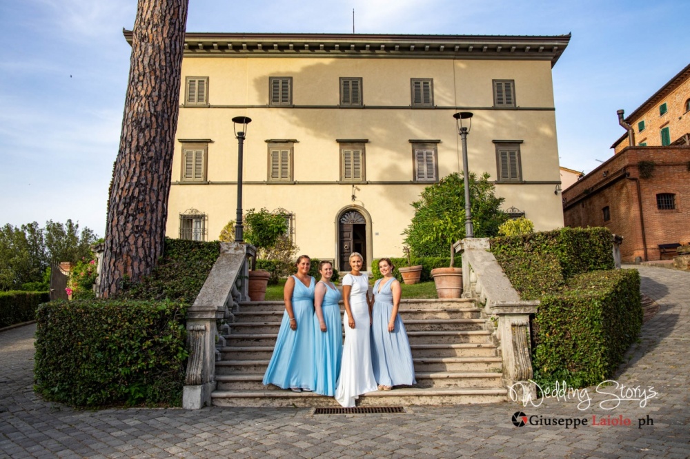 le damigelle e la sposa sulla scalinata dell'esclusiva villa storica in Toscana