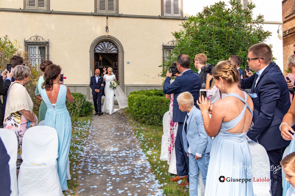 il padre della sposa la accompagna verso lo sposo nell'esterno della location esclusica per nozze